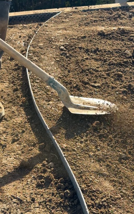 Nivellement des terres pour la mise en place de la bordure à Groisy