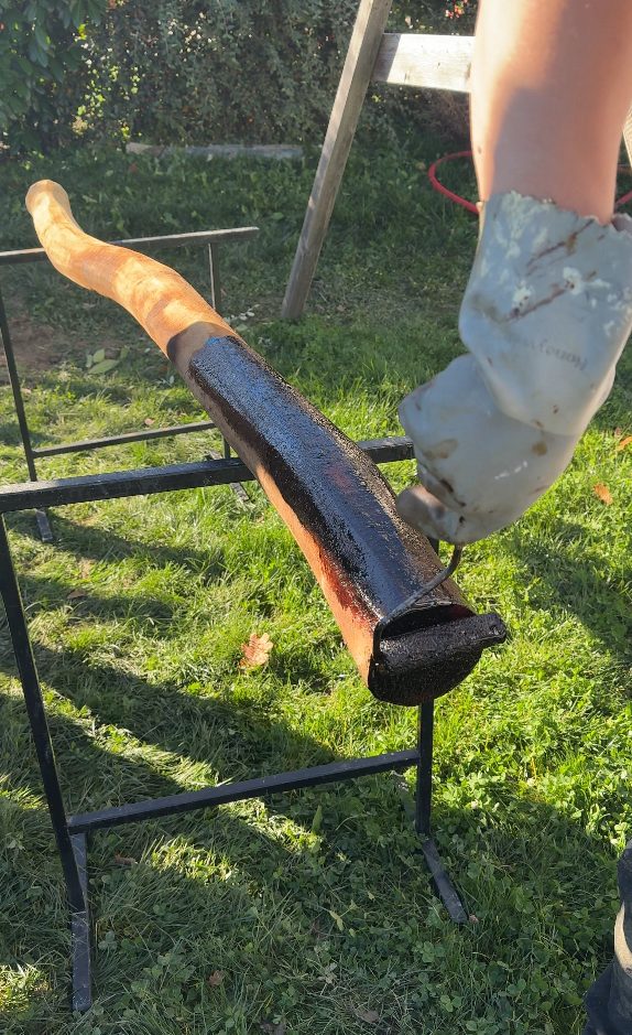 Traitement des pieds de poteaux au goudron de Norvège avant scellement à Groisy
