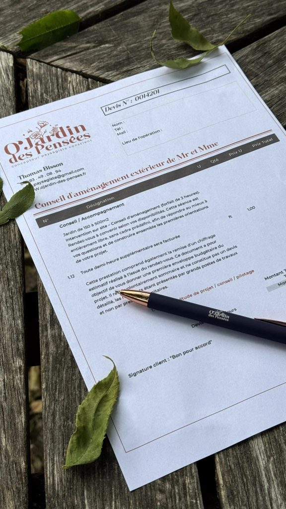 Devis d’accompagnement O’Jardin des Pensées pour un conseil d’aménagement extérieur, posé sur une table en bois avec un stylo