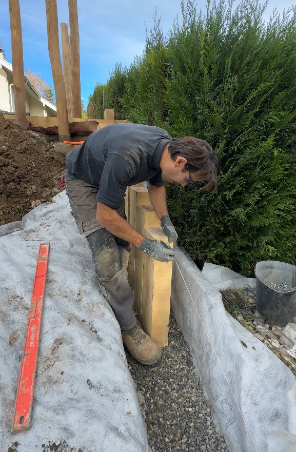 Positionnement des traverses de chêne du mur de soutènement à Groisy