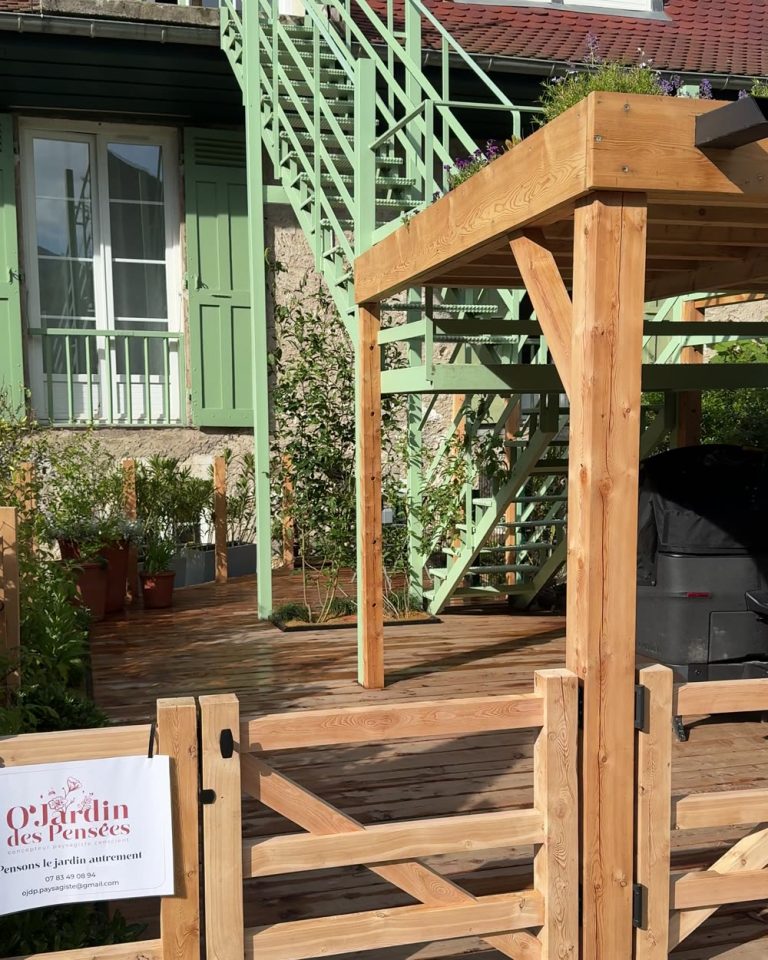 Cour à Sevrier après travaux : platelage bois, pergola à toiture plantée, clôture et portillons en bois