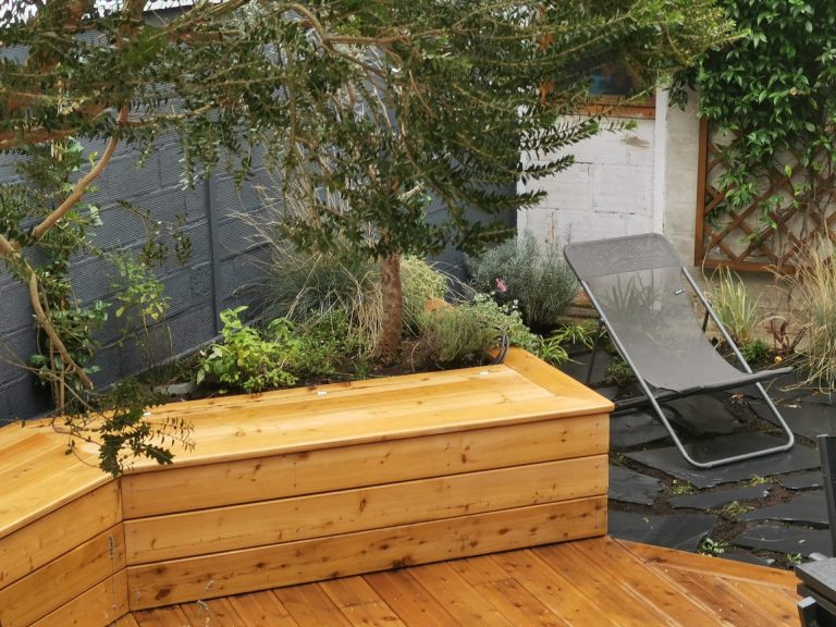 Le banc en mélèze intégré à une jardinière plantée au dos à Colombes (92)