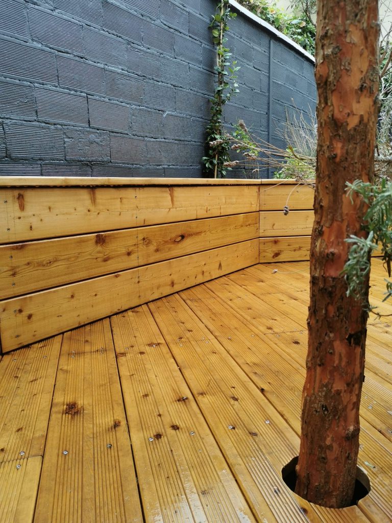 Le tronc de l’arbre traversant la terrasse en mélèze à Colombes (92)
