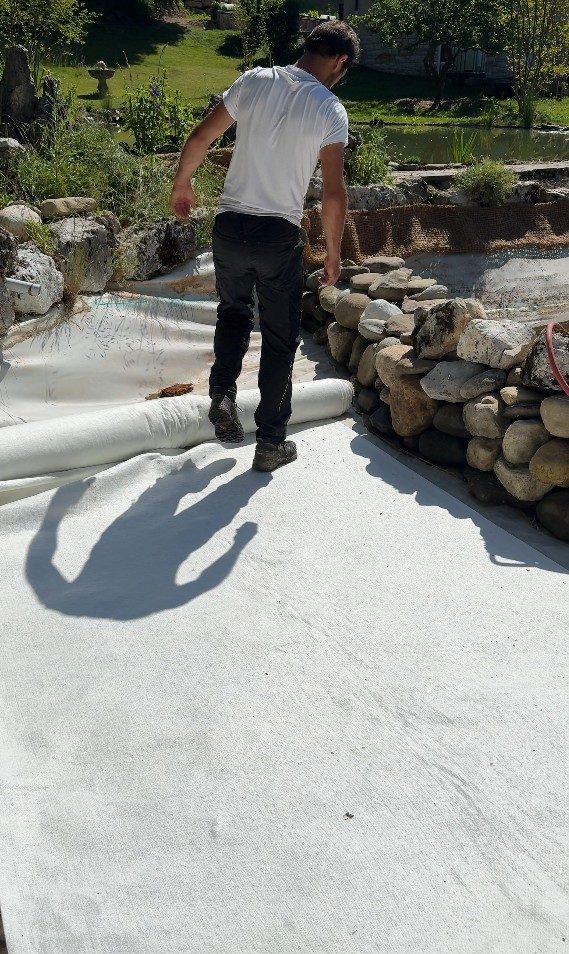 Géotextile anti-poinçonnement posé sur la bâche EPDM de la lagune, à Cruseilles (74)